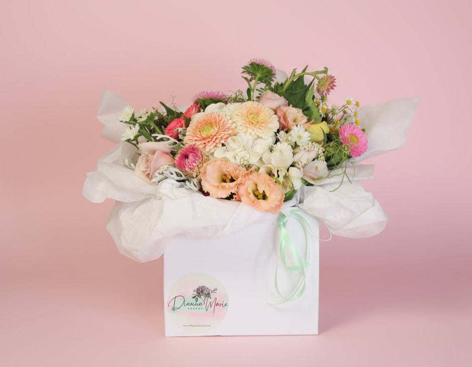 Petite flower posy with  in a small gift bag with blush, pastel and pink fresh seasonal blooms, created by our Pukekohe florists.